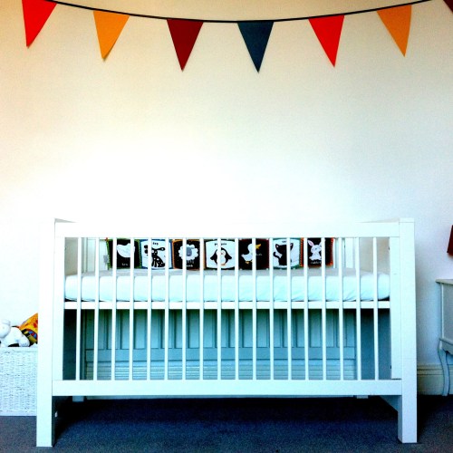 Hand me down cot from big sis, and paper bunting made by me when heavily pregnant